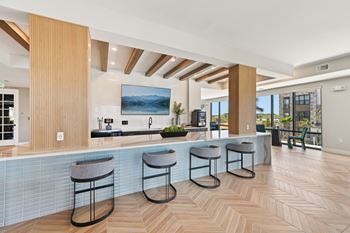 A kitchen with a bar area and a painting hanging above the counter.